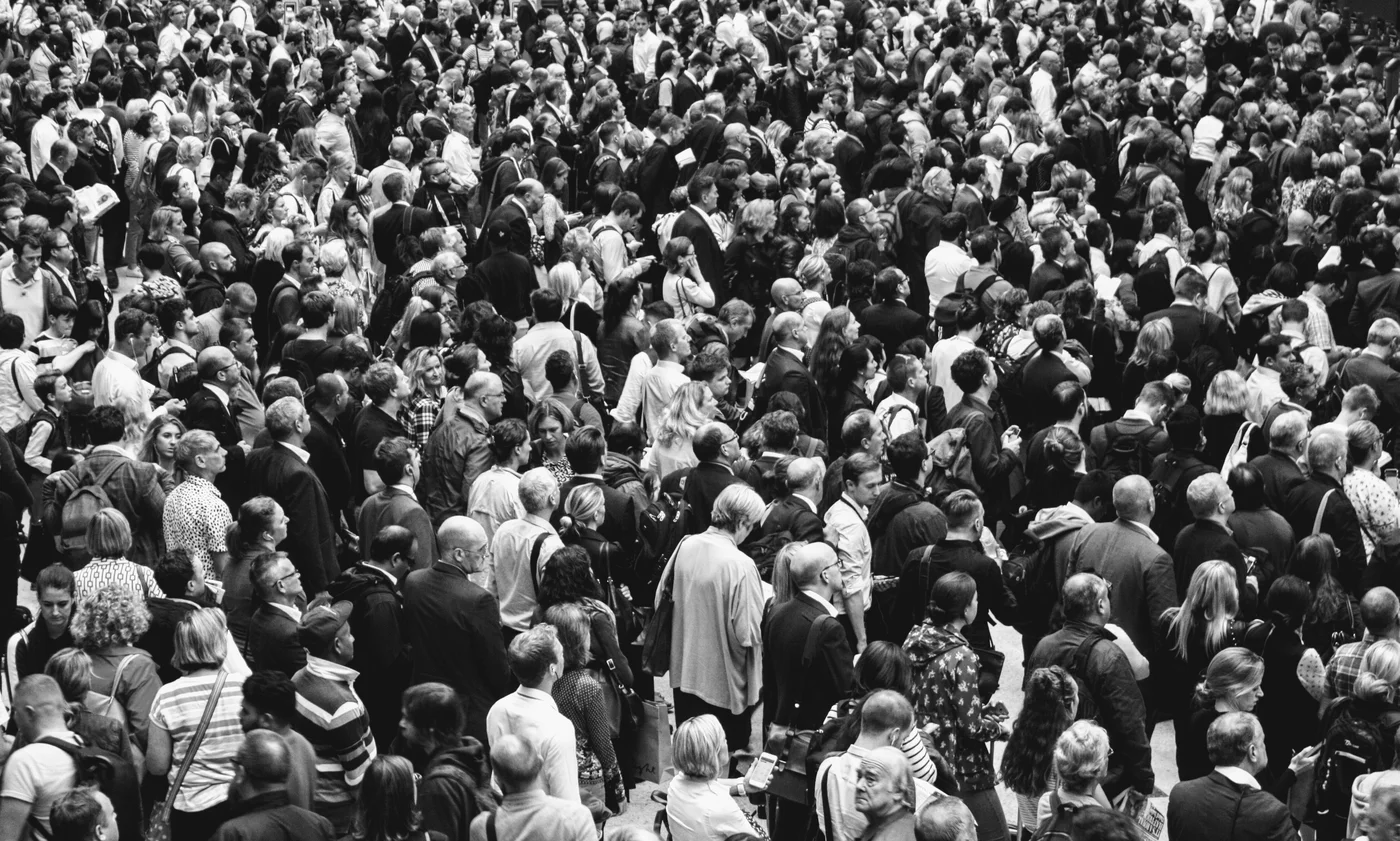 Une foule dense vue en plongée, photographiée en noir et blanc.