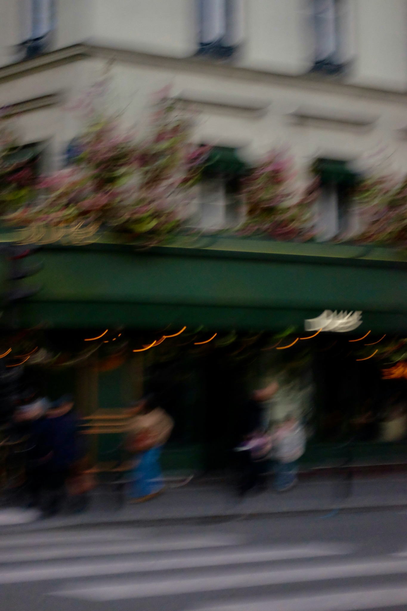 Louis Le Pessot / Unsplash Passants devant un café parisien, photographiés dans un flou de mouvement.